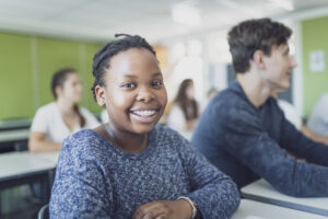 Portrait of African-American teenage female student smiling in classroom Invisalign Portage